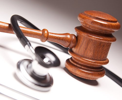Marteau de juge et stéthoscope sur un bureau